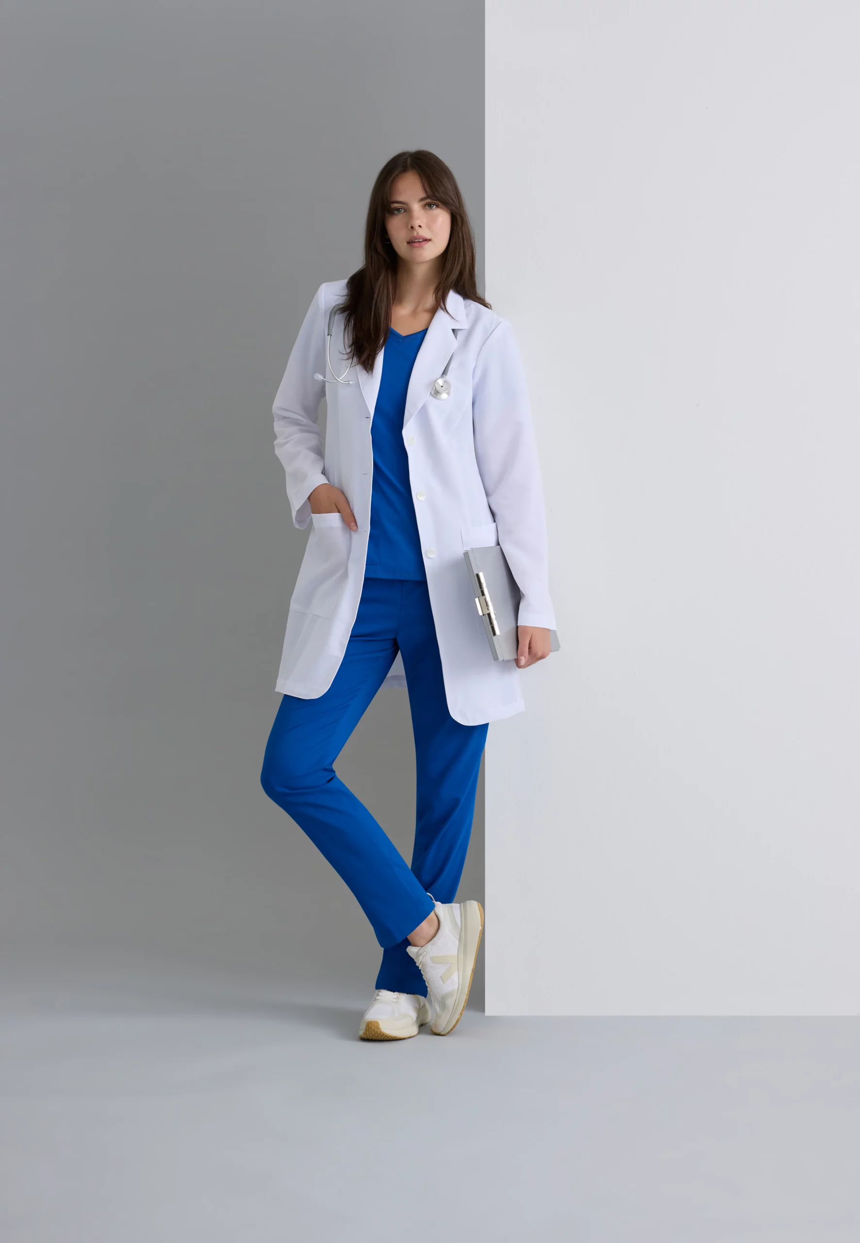 Healthcare professional in blue scrubs and white lab coat